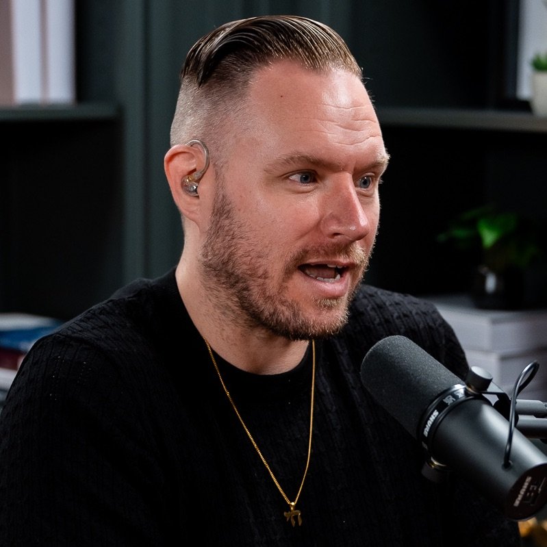 Travis Hawley speaking into a microphone during a podcast interview